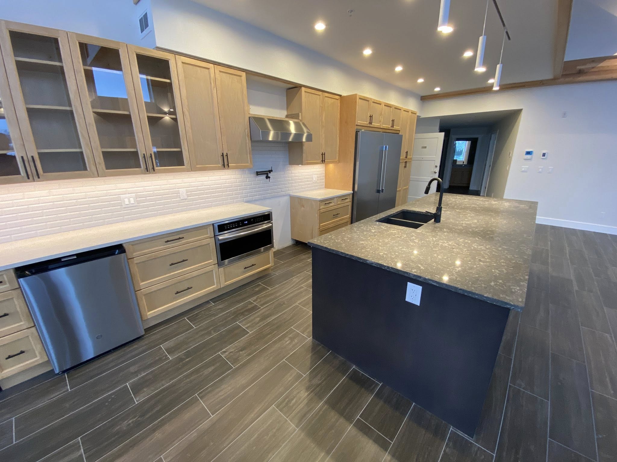 Finished kitchen with hardwood floors and quartz workspace.