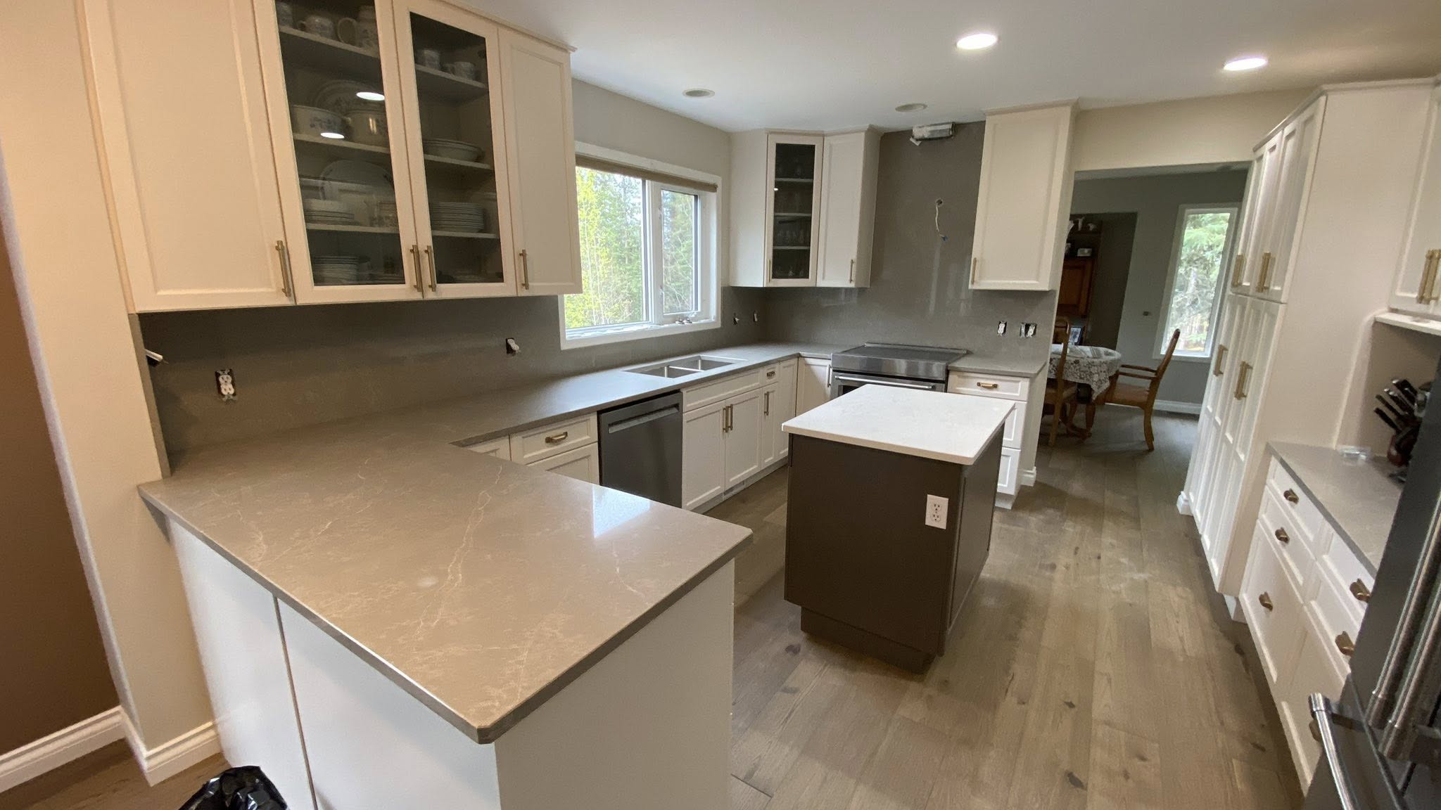 Modern white shaker kitchen with grey-tone quartz countertops.