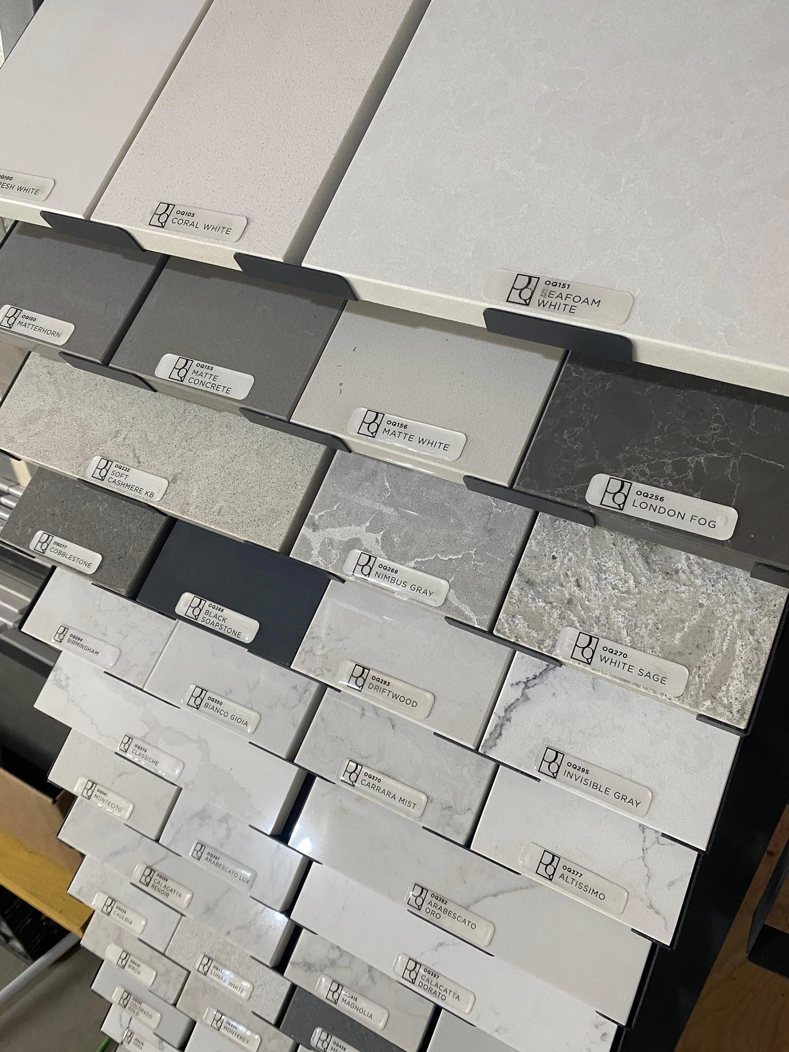 Display rack of quartz countertop samples showing whites, greys, and marbled patterns