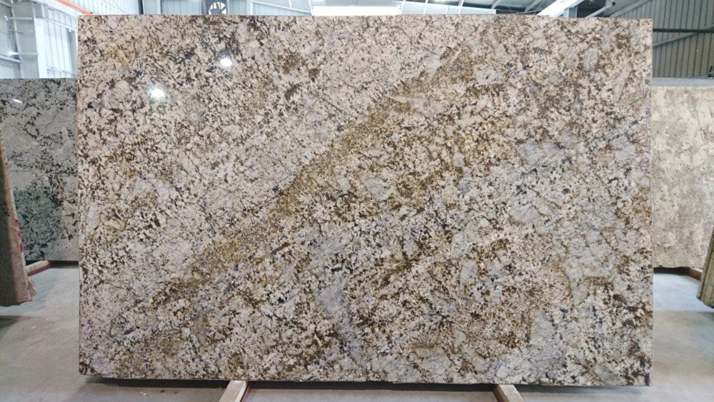 Warm-toned golden granite slab with rich movement and beige-and-white grains.