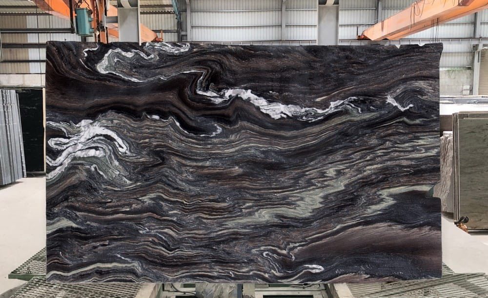 Dramatic black granite slab with white-and-cream river-like veining at the warehouse.